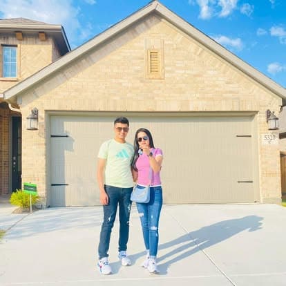 New homeowners in front of their house